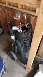 Two sets of golf clubs with hand carts