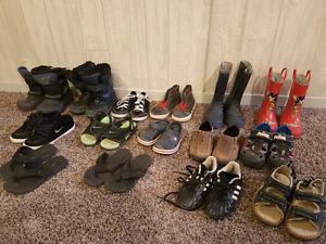 Lots of boys shoes and boots and sandals