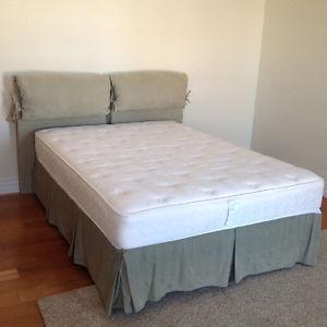 Double size bed with headrest and mattress.