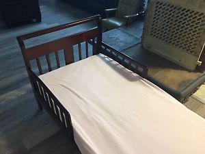 Toddler bed with mattress and several sheets
