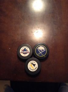 3 NHL pucks with the teams old logos