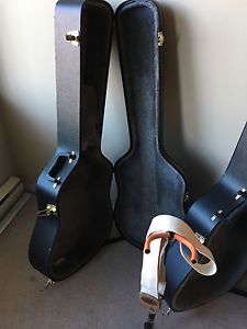 Two acoustic guitar cases, guitar stand and guitar strap
