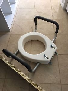 Raised toilet seat with handles