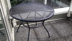 Black metal patio table and stackable chairs