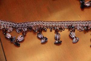 Beaded decorative trim in brown with teal accent.