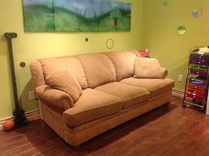 Caramel colored sofa with throw cushions