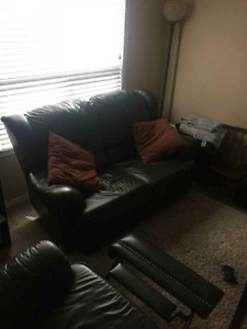 Green leather reclining sofa and love seat.